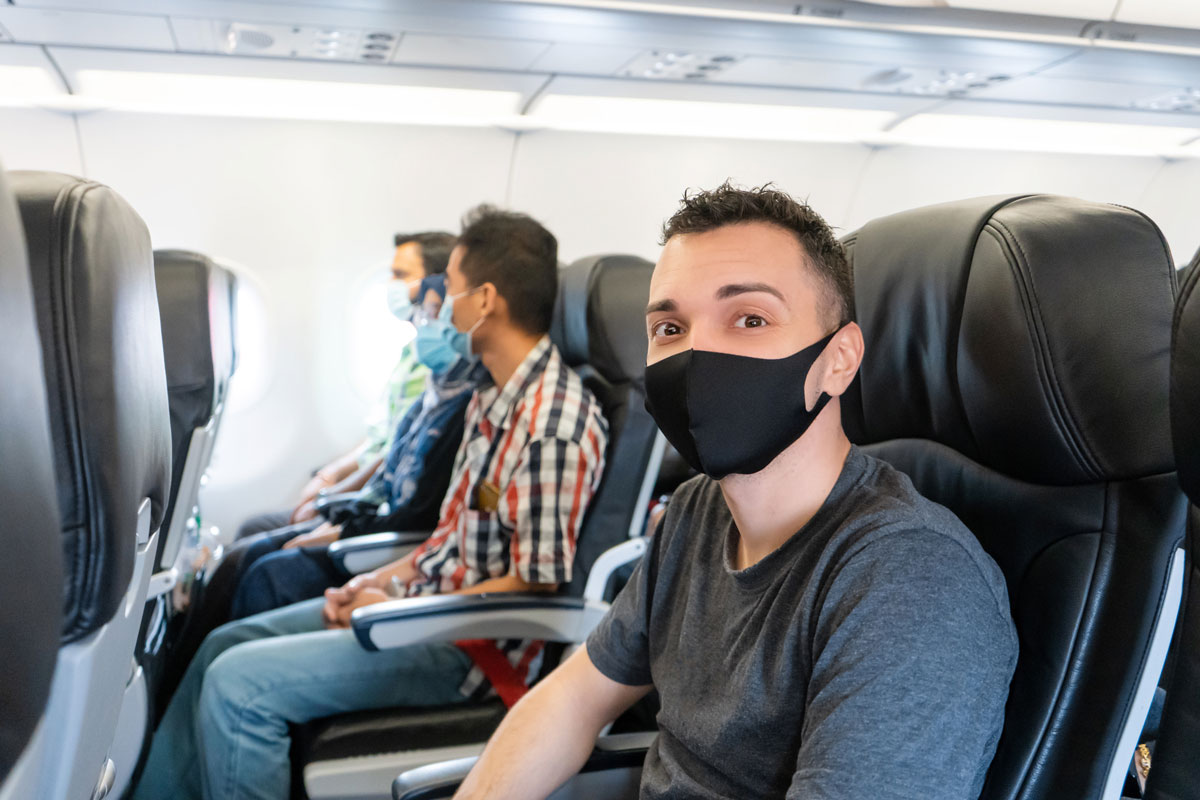 men with masks on airplane